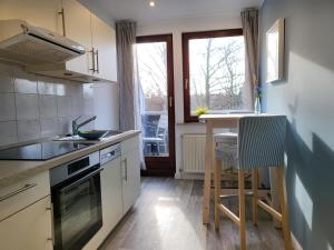 een keuken met een aanrecht, een tafel en een raam bij Ferienwohnung 4 in der Waldstraße in Sankt Peter-Ording