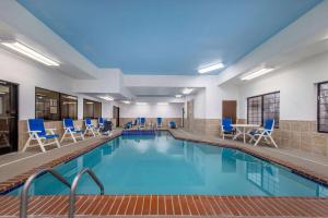 - une piscine avec des chaises bleues et une table dans l'établissement Baymont by Wyndham Pratt, à Pratt