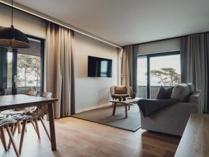 a living room with a couch and a table and chairs at Åhus Seaside in Åhus