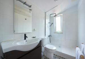 a white bathroom with a sink and a toilet at Bright Apt w Balcony, AC, Parking, By TimeCooler in Lisbon