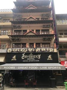 金邊的住宿－Riverside Hotel Phnom Penh，一座建筑,上面有读房间的指示牌,有很好的现场体育节目