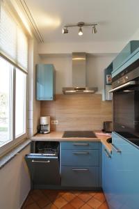 a kitchen with blue cabinets and a stove at Hamburg-App-05 in Ahlbeck