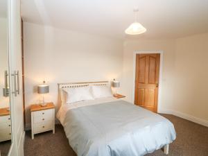 a bedroom with a white bed and a wooden door at Ballycahane in Castletownshend