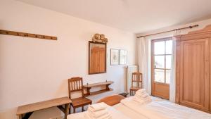 um quarto com 2 camas, uma mesa e uma janela em Ferienwohnung Eichhorn em Schwangau
