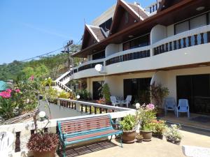 a bench sitting outside of a building with plants at Blue Sky Residence in Patong Beach