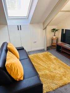 a living room with a black couch and a television at City Blessed Apartment 4 with free parking in North Shields