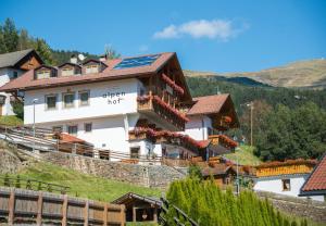 una casa con paneles solares en la cima de una colina en MOUNTAIN RESIDENCE ALPENHOF - company Hotel Alpenhof KG sas der Gasser Renate en Bressanone