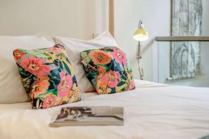 a bed with two pillows with a book on it at The Trinity in Stow on the Wold