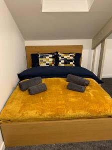 a bedroom with a large bed with a yellow blanket at City Blessed Apartment 4 with free parking in North Shields