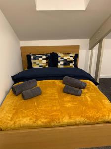 a bedroom with a large bed with a yellow blanket at City Blessed Apartment 4 with free parking in North Shields