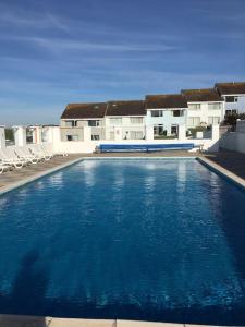 a large blue swimming pool in front of a building at 34 Surfview Beach House in Newquay