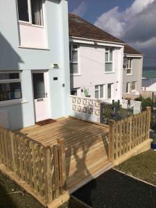 a wooden deck in front of a white house at 34 Surfview Beach House in Newquay