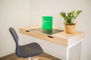 a desk with a chair and a book and a plant at Lovely 3 Bedroom Apartment in Eindhoven 65m2 - SD23N in Eindhoven