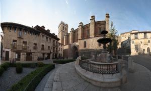 a building with a fountain in the middle of a street at Hotel Mora in Mora de Rubielos