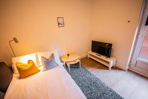 a bedroom with a bed and a table and a tv at Lovely 3 Bedroom Apartment in Eindhoven 65m2 in Eindhoven