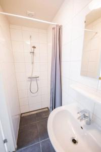 baño blanco con ducha y lavamanos en Lovely 3 Bedroom Apartment in Eindhoven 65m2 en Eindhoven