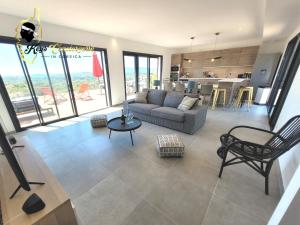 ein Wohnzimmer mit einem Sofa und einem Tisch in der Unterkunft Casa Balancinu Vue panoramique sur montagne et Mer Piscine Privée in Sainte-Lucie de Porto-Vecchio