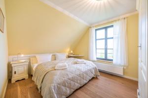 a bedroom with a bed and a window at Reethaus ZEESENBOOT am Golfplatz in Lohme