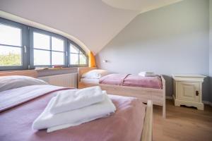 two beds in a room with two windows at Reethaus ZEESENBOOT am Golfplatz in Lohme