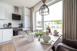 une cuisine et une salle à manger avec une table en bois et une fenêtre dans l'établissement Villa "Zweite Heimat - Exklusive Penthouse No 3, à Lohme