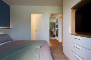 a bedroom with a bed and a flat screen tv at Villa am Schloss Ranzow L3 Lohme Luxury Living in Lohme +6 photos