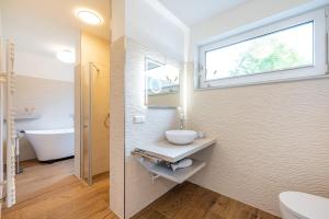 baño con lavabo y aseo y ventana en Villa 17 Appartement Blickwinkel, Lohme, en Lohme