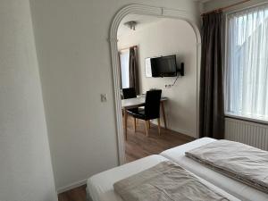 een hotelkamer met een bed en een spiegel bij Appartementen Beatrix in Domburg