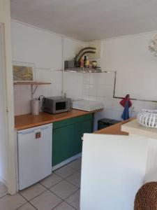 Cottage Egmond-Binnen met besloten tuin في إيجموند-بينن: مطبخ مع ثلاجة بيضاء وميكرويف
