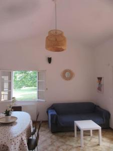 ein Wohnzimmer mit einem blauen Sofa und einem Tisch in der Unterkunft Maison indépendante sur notre propriété in Hyères