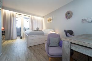 ein Schlafzimmer mit einem Bett, einem Tisch und einem Stuhl in der Unterkunft Berolina Wohnung 315 in Dahme