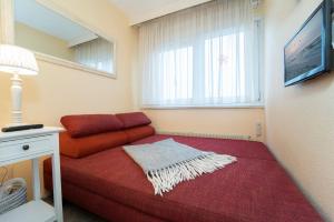 ein Wohnzimmer mit einem roten Sofa und einem Fenster in der Unterkunft Berolina Wohnung 315 in Dahme