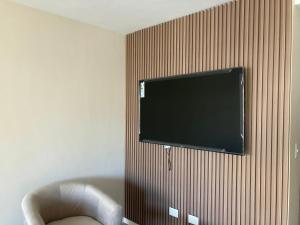 TV de pantalla plana colgada en la pared en C&R APART en Mar del Plata
