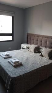 1 dormitorio con 1 cama grande y 2 toallas. en C&R APART en Mar del Plata