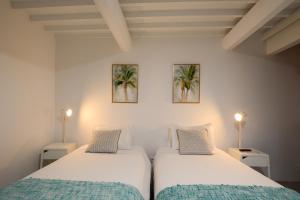 two twin beds in a room with two lamps at Quinta do Paraizo in Ribeira Grande