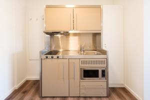 a kitchen with stainless steel appliances and a sink at TEERHOF58 in Bremen