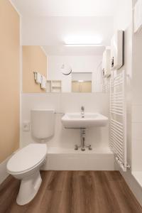 a white bathroom with a toilet and a sink at TEERHOF58 in Bremen