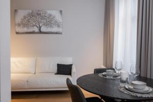uma sala de estar com uma mesa e um sofá branco em Lutsu Residents - Unique apartment in Old Town, Keyless em Tartu
