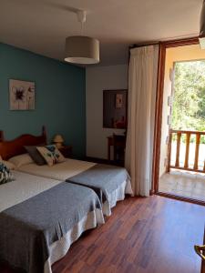 a bedroom with two beds and a large window at La Salmonera Cangas de Onís in Caño