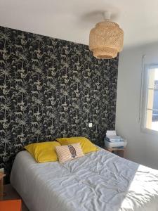 een slaapkamer met een bed met zwart en wit behang bij Maison avec piscine privative in Biganos