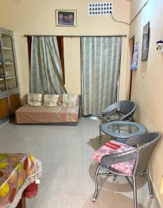 sala de estar con sofá, sillas y mesa en Divine view - 1 bhk AC - Swarna Bhavan, en Puri