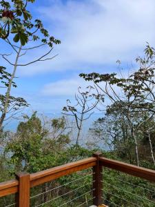 una valla de madera con árboles en el fondo en Casa no Sul da Ilha, en Ilhabela