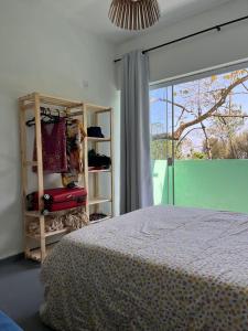 1 dormitorio con cama y ventana grande en Casa no Sul da Ilha, en Ilhabela