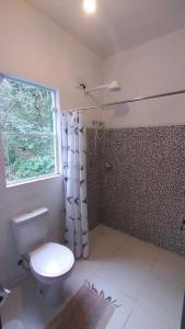 baño con aseo y ducha y ventana en Casa no Sul da Ilha, en Ilhabela