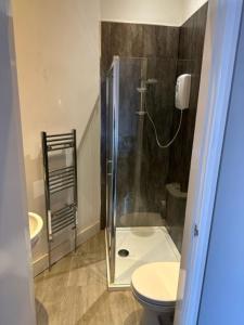 a bathroom with a shower with a toilet and a sink at The Grosvenor Free house in Scunthorpe