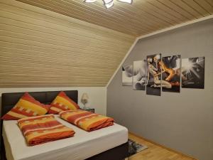 a bedroom with a bed with pictures on the wall at Hell und gemütlich, ca. 60qm. in Osnabrück