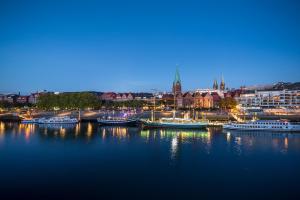 a group of boats docked in a harbor at night at TEERHOF58 in Bremen