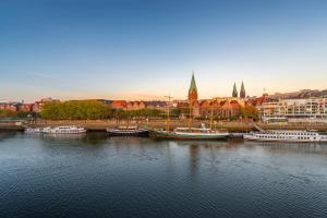 a group of boats docked in a river with a city at TEERHOF58 in Bremen +7 photos