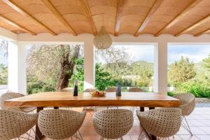 Une table et des chaises en bois sont disponibles sur la terrasse. dans l'établissement Oasis Living Villa Can Ramon, à Cala Llonga