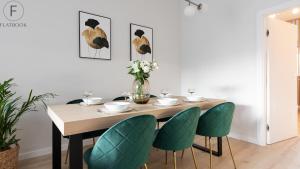 a dining room table with chairs and a vase of flowers at Flatbook - City Center Apartments Granaria in Gdańsk