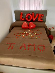 Una cama con las palabras de amor escritas en ella en Casa Marisa Pozzuoli, en Pozzuoli